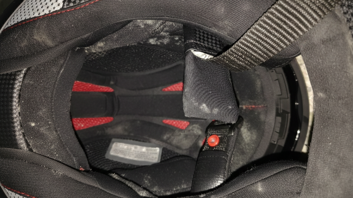 Close-up of motorcycle helmet interior showing sweat-stained padding and liner after daily use by a bike rider
